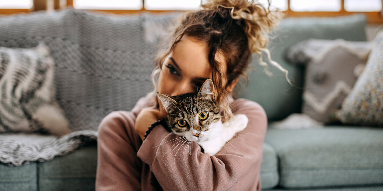 Young woman bonding with her cat in apartment